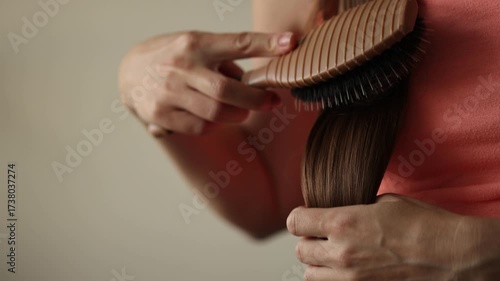 Woman brushing her hair and after takes loss hair out of the brush.. Closeup, selective focus. 4K