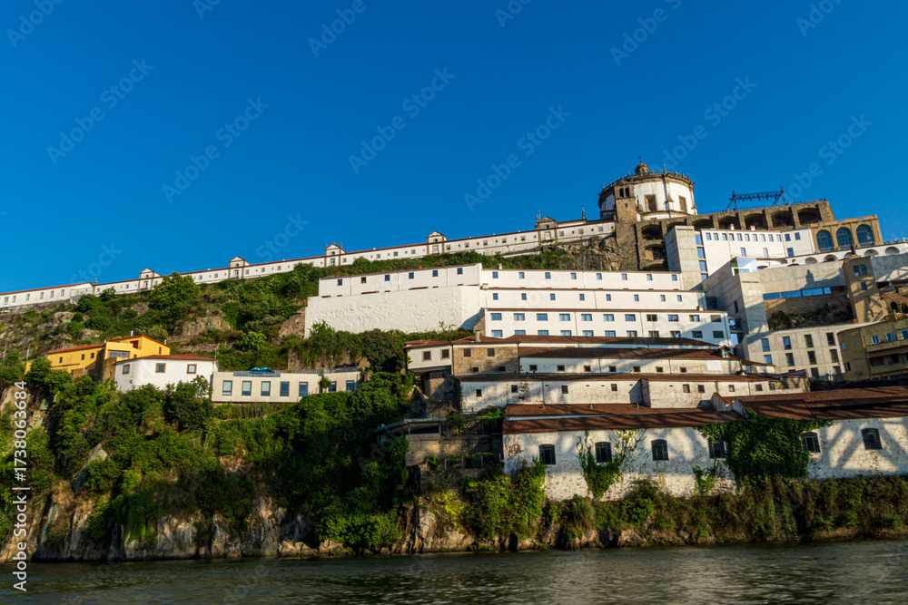Obraz premium Scenic view of Serra do Pilar Monastery and historic hillside buildings by the Douro River in Vila Nova de Gaia, Portugal.