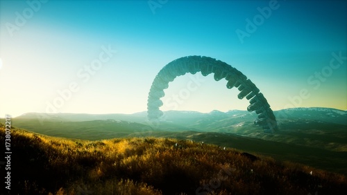 Fotografie In a breathtaking sunrise, an enigmatic arch hovers above rolling hills