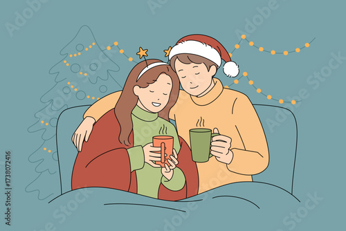 A cozy holiday couple is happily enjoying their hot drinks together by the fireplace