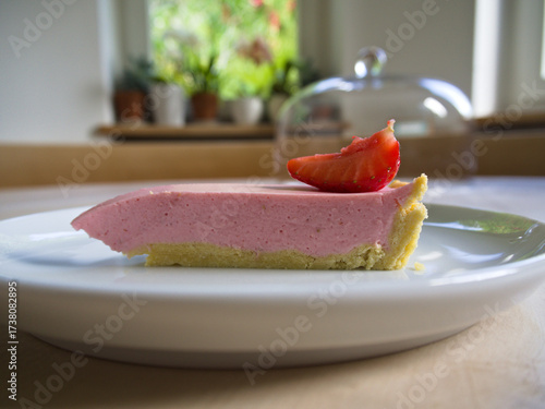 Clean slice of a home baked strawberry cake in an elegant setting. 