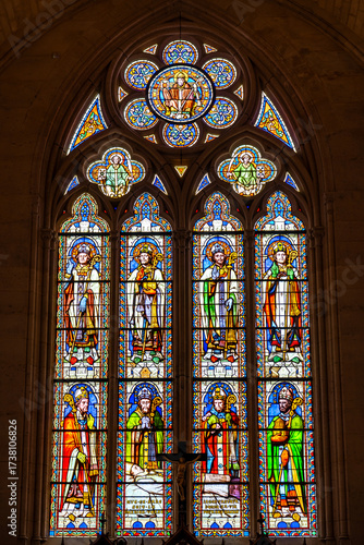 Stained-glass window with religious decoration inside french cathedral.