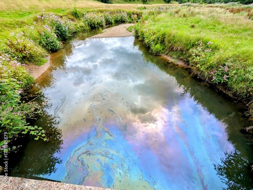 Oil pollution contaminating River Dean in Cheshire, England, UK.