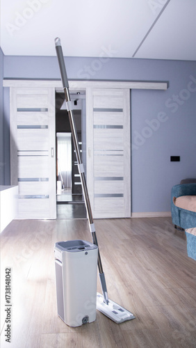 Modern mop with wringing bucket in room against room interior background. Apartment cleaning, close-up