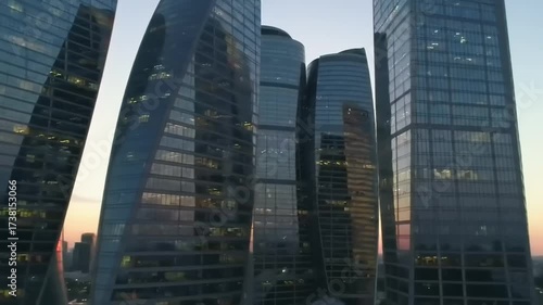 Modern skyscrapers at sunset with glass facades and reflecting light