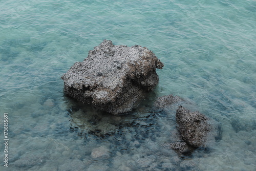 A Serene Coastal Rock Formation Surrounded by Clear, Sparkling Water and Scenic Views