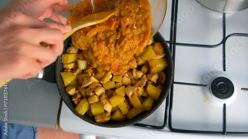 Chef cooking stew pouring vegetable sauce on chicken and potatoes on kitchen. Culinary techniques, homemade preparing healthy meal cook meat vegetables food, organic cuisine from fresh ingredients.