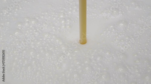 4K footage Close-up shot of fresh milk being poured into metal container smooth foamy texture and clean white color.