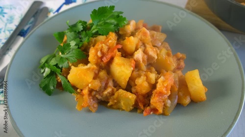 Served vegetables potatoes and chicken meat stew with parsley on plate on kitchen. Culinary techniques, homemade preparing healthy meal cook food, organic cuisine from fresh ingredients.