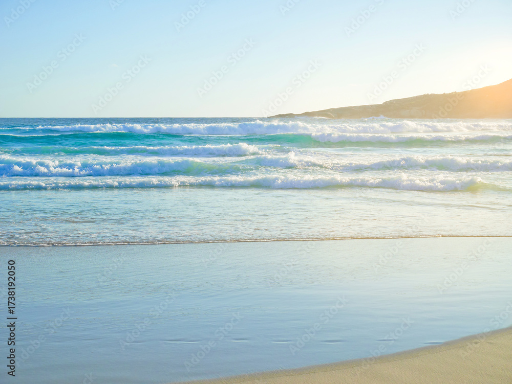 Obraz premium The wave crashing against the beach at sunset