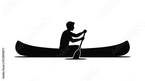 Silhouette of a person paddling a canoe across calm waters