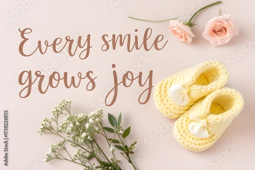 Yellow knitted baby shoes with flowers and heartwarming text