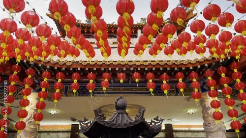 Red lanterns hang over a traditional incense burner at Thean Hou Temple in Kuala Lumpur, Malaysia, symbolizing culture and devotion