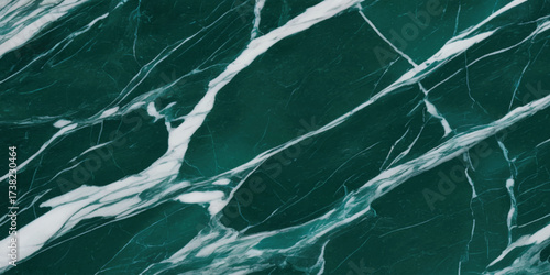Green marble surface close-up with elegant white veining and organic natural stone texture background.