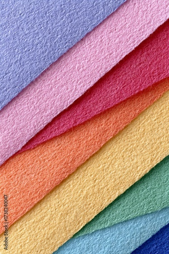Multicolored textured paper sheets layered in rainbow spectrum