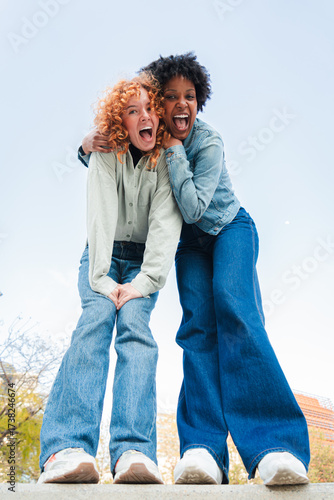Two exuberant friends sharing a lively and enthusiastic moment filled with joy and laughter, embodying the essence of friendship and happiness in a delightful interaction that radiates energy.