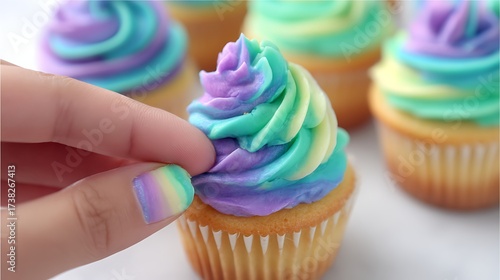 Colorful Rainbow Swirl Cupcake with Soft Frosting on White Background