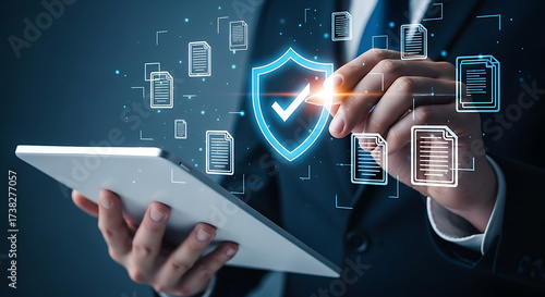 Businessman interacting with digital security shield and data documents on tablet