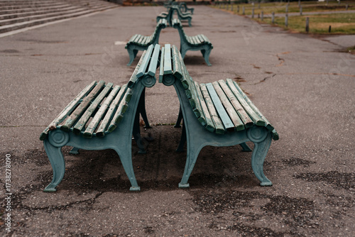 Old benches stand in a row on the street.