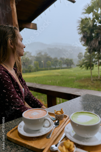 A Serene Moment of Reflection: Enjoying Warm Beverages Amidst Rainy Landscape in a Tranquil Natural Setting