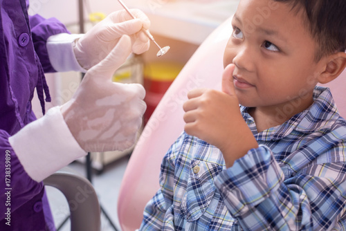 Close up dentist hand examining patient tooth on dental chair. Professional dentist making teeth cleaning patient at the dental office.