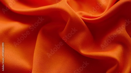 A vibrant orange wrinkled fabric texture background. Close up.