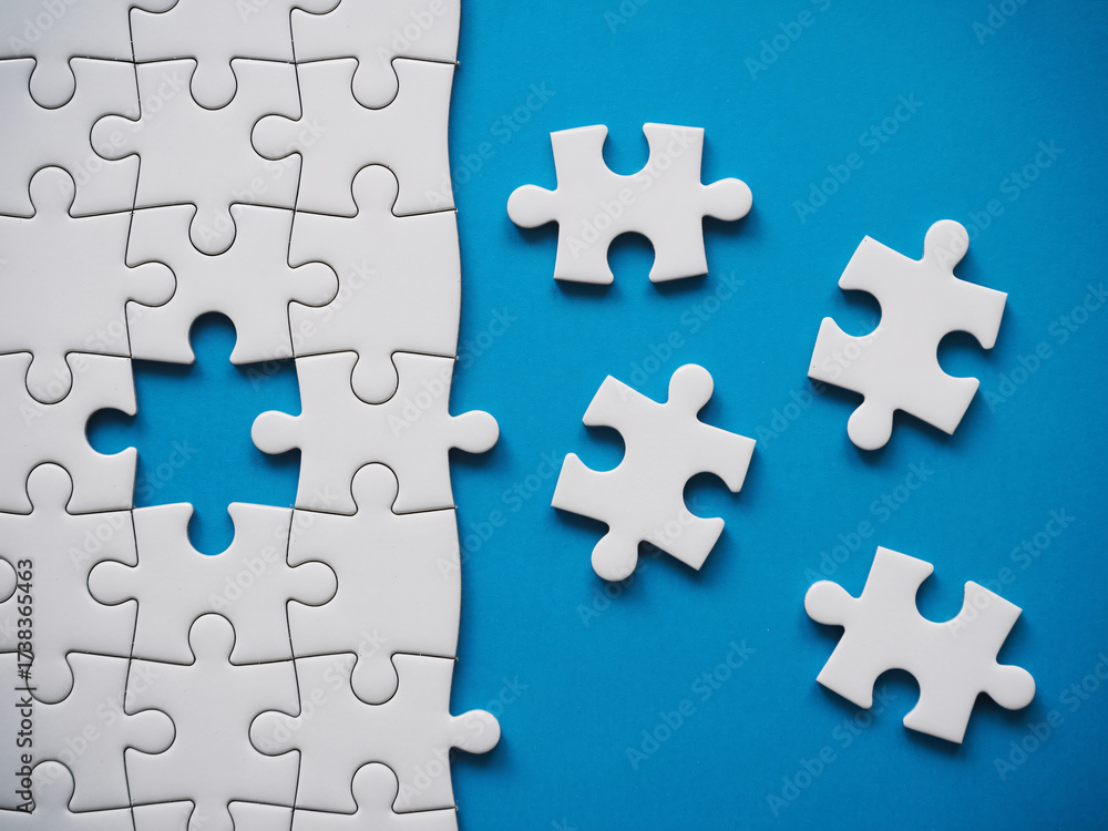 Obraz premium Solving complex business problems with a modern white puzzle on blue background illustrating strategy and creative solutions