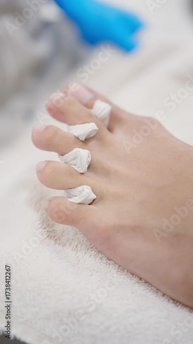 Pedicurist applying toe separators during nail treatment
