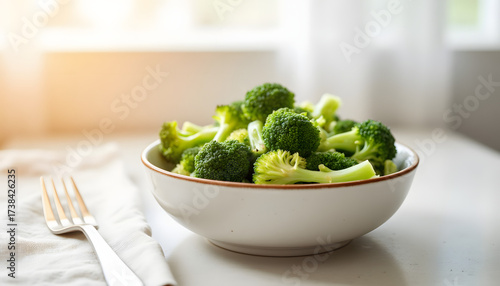 Fresh broccoli in a bowl on a table with sunlight from window  