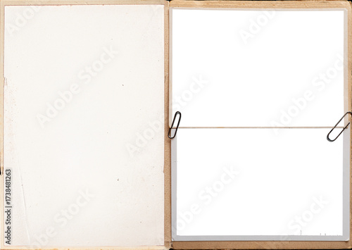A vintage book pages with blank photo frames attached with paper clips.