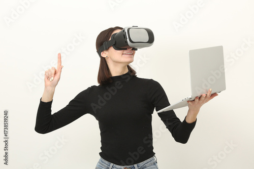 Φωτογραφία Woman in VR Headset Holding Laptop Above Head