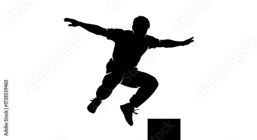 Silhouette of a man performing a parkour jump over a block freerunning action