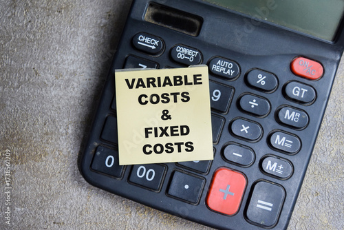 Concept of Variable costs and fixed costs write on sticky notes isolated on Wooden Table.