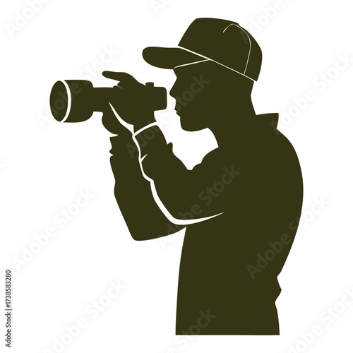 Silhouette of a person wearing a hat holding and operating a video camera