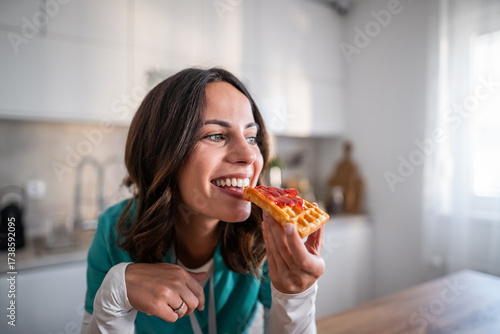 Canvastavla Woman smiling happily eating breakfast waffle with jam