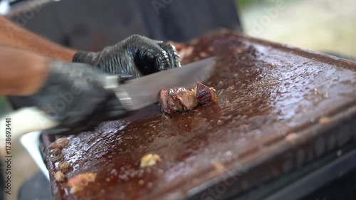 barbecue chef cutting barbecue meat with glove