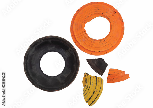 Broken clay targets in orange, black, and yellow are scattered on a white surface.