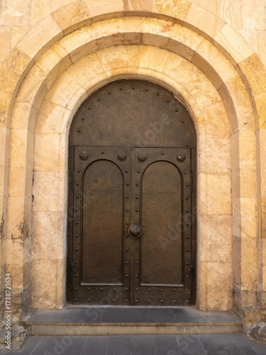Wallpaper Mural Close view of ancient stone church door with decorative arch in Tbilisi, Georgia.
 Torontodigital.ca