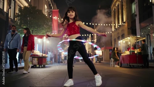 Young girl hula hooping at a festive outdoor event