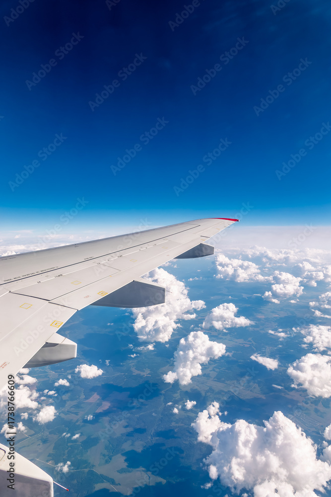 Obraz premium View from the airplane window at a beautiful cloudy sky and the airplane wing
