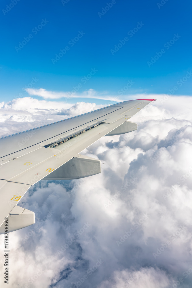 Obraz premium View from the airplane window at a beautiful cloudy sky and the airplane wing