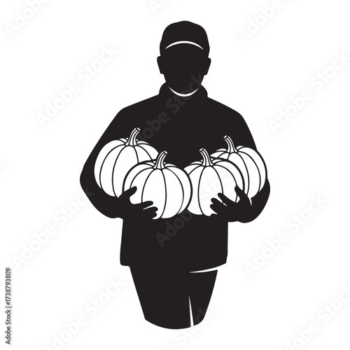 Silhouette of a farmer wearing a cap holding a bounty of ripe pumpkins in his arms during harvest season