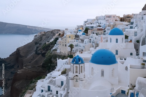 Picturesque Oia Village on Santorini Island, Greece, featuring white buildings and iconic blue domed churches.
