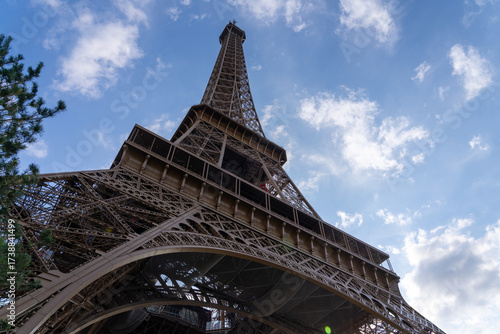 Eiffel Tower against a blue sky with clouds.