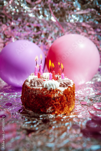 Happy birthday cake with burning candles with pink and purple air balloons, vertical card  on silver background 