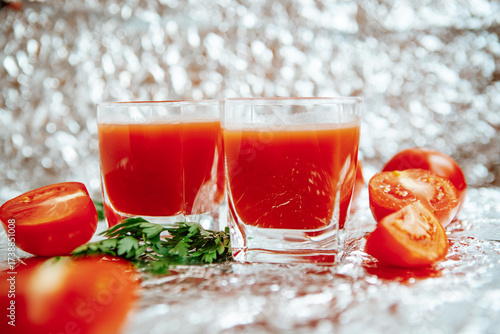 Fresh red tomato juice on silver background 
