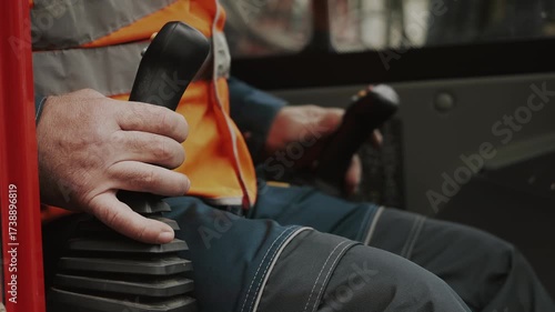 A close-up of the hands of a worker operating a joystick. Controls of heavy construction equipment. The operator controls an excavator.