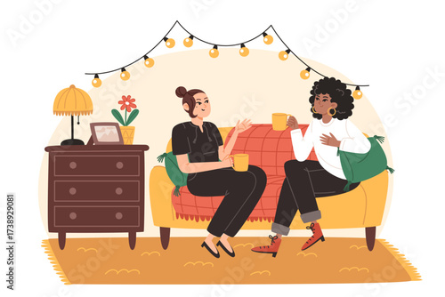 Two women talking on a couch with mugs and string lights