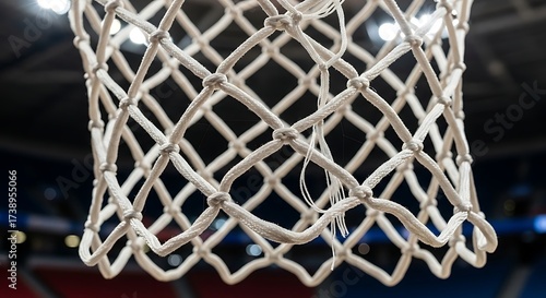 Close-up view of a white woven basketball net, showing the intricate knotting and texture of the material against a blurred background.