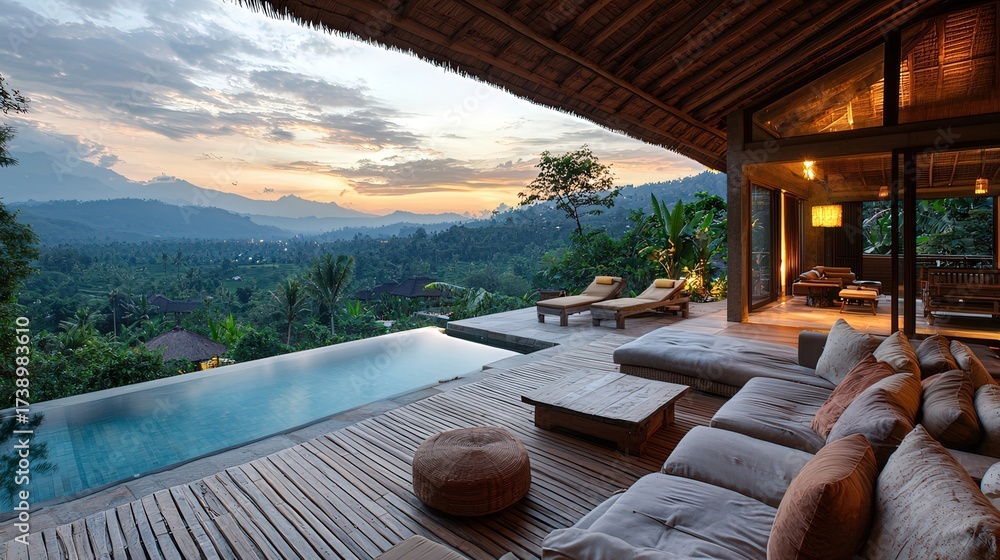 Fototapeta premium Infinity pool overlooks mountains and lake with lounge chairs at sunset.